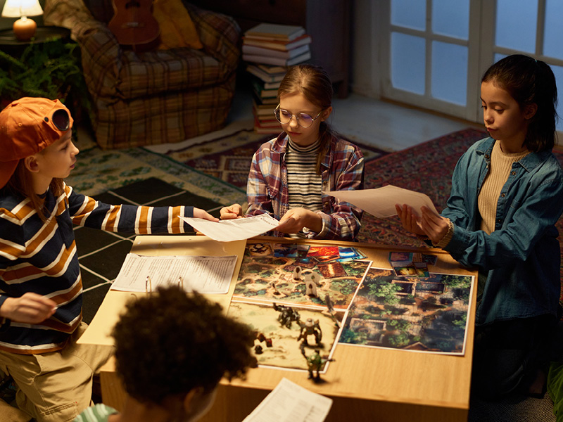 Kids sit around a table playing a role-playing game